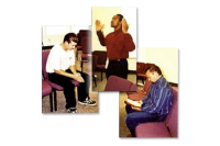 Three men sitting in chairs and one man is holding a book.